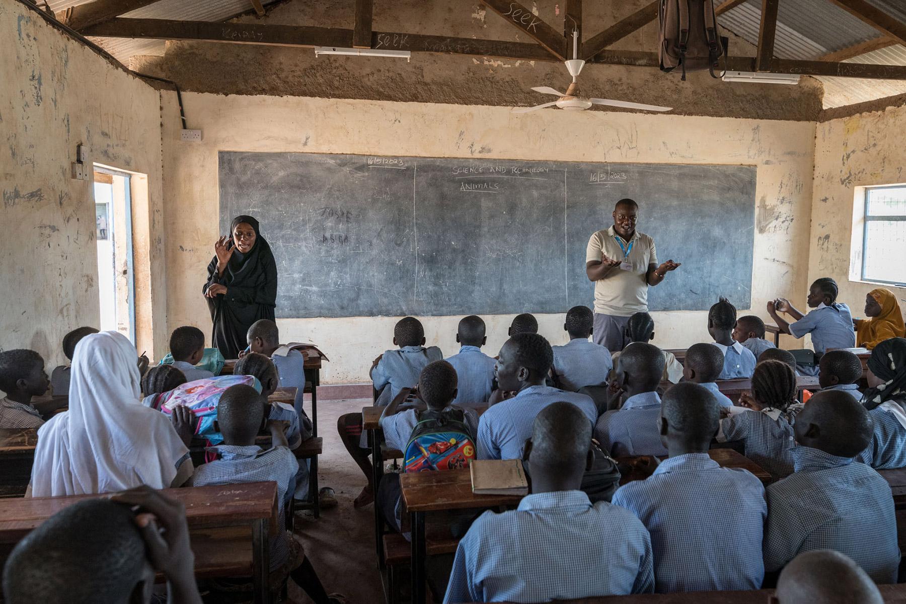 La clase está en marcha en la Escuela Primaria Shabele, impartida por el maestro Rogers Juma (derecha) y con interpretación en lenguaje de señas impartida por la Asistente de Apoyo al Aprendizaje Amiza Lumumba (izquierda). Fotografía: FLM/ Albin Hillert