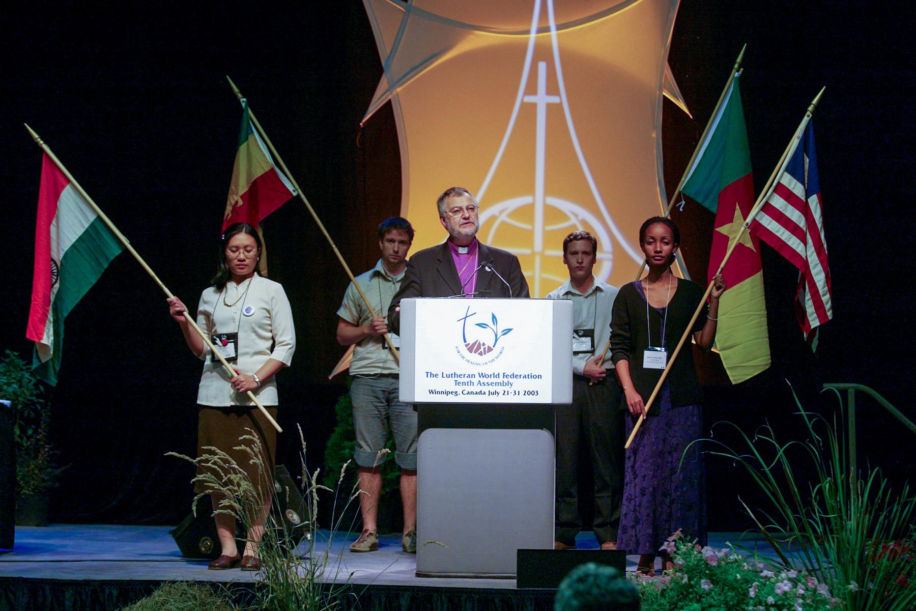 Benny Sinaga holding a flag as a youth delegate at the opening of the LWF Assembly in Winnipeg, Canada. Photo: Private