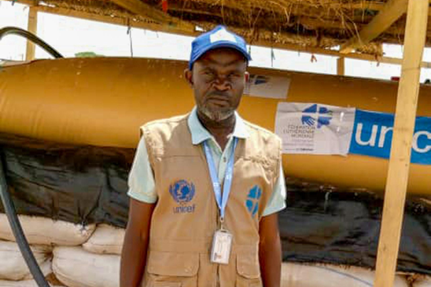 Roger Kalimira, in front of a water bladder he helped install. Photo: LWF/ M. Idjawo