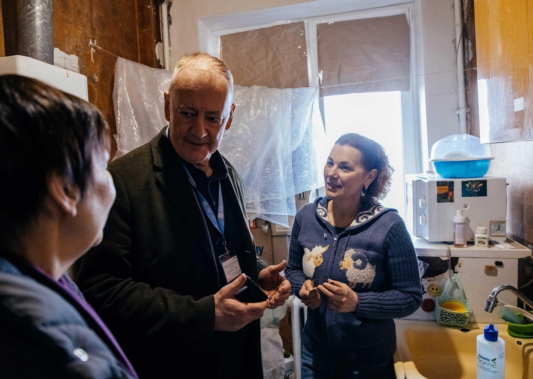 Mark Mullan, LWB-Teamleiter in der Ukraine, spricht mit Einwohnern des Charkiwer Stadtteils Saltiwka, deren Wohnungen der LWB saniert hat
