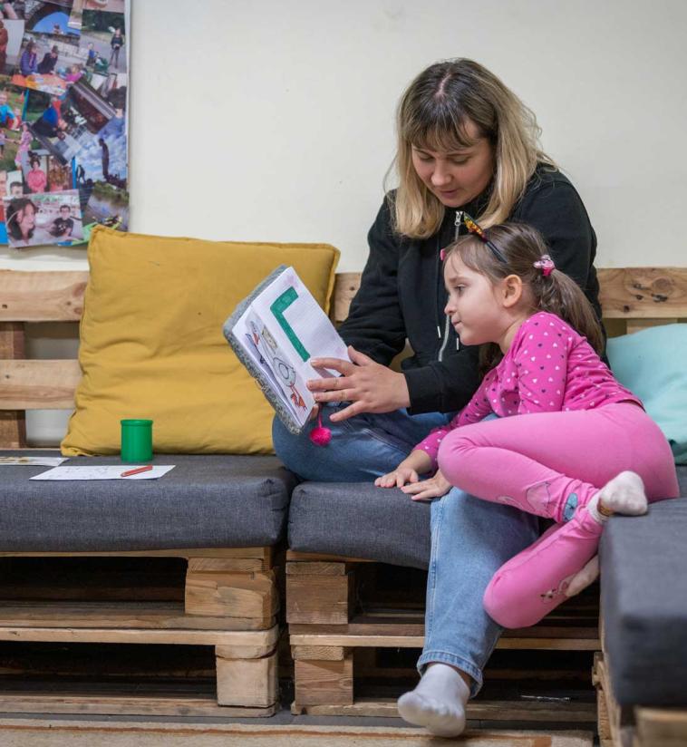 Katiia Kharytoniuk (37) and her daughter Sofija (5) practice the alphabet together. Katiia arrived as a refugee in Poland from Uman, Ukraine, together with her two daughters. After three months staying in the home of a Polish family, she now lives with her daughters in a building at the Evangelical Church of the Augsburg Confession in Poland parish in Bytom. The father of the family remains in Ukraine, as men aged 18-60 are not allowed to leave the country. Photo: LWF/Albin Hillert