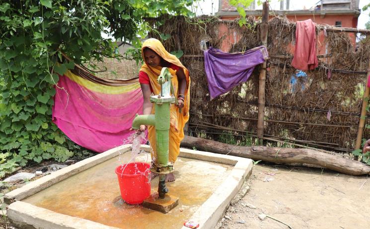 Ms. Rohini Devi Paswan, a resident of Dhanusa, drawing water from a newly constructed hand pump – Photo credit: Suman Rai/LCWS