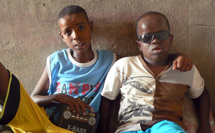 Blind but not illiterate: Mahomed, right, is blind but intelligent and learns about the world through the radio his brother holds. Photo: ALWS/Jonathan Krause