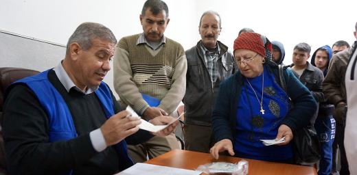 Gorgya Paols, 63, receives a LWF food voucher, entitling her to a carton of food that will last a month. Despite the violence she fled in 2005 and the worsening situation since the ISIS insurgency, her single wish is for peace in Iraq. Photo: LWF/S. Cox