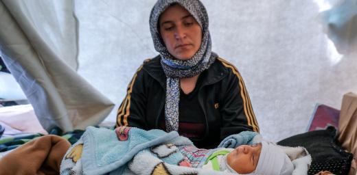 Caption: Kamla Edno and her five-day-old baby, Shahla Edno, at the Berseve 1 camp near the town of Zakho in northern Iraq in December 2014. The baby lies in a plastic crate used to store vegetables. Photo: LWF/ S. Cox