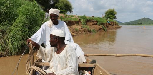 Djouma Ousmane (in the back) ferries members of the community across the river with a boat they bought with collective income from an LWF livelihoods initiative. Photo: LWF Chad