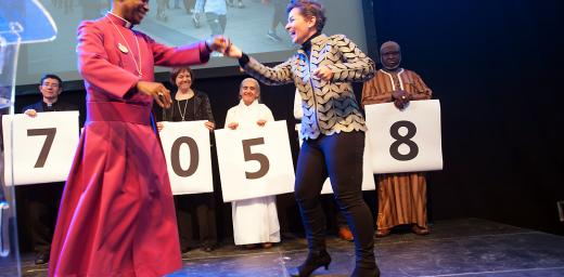 Christiana Figueres, Executive Secretary of the United Nations Framework Convention on Climate Change, dances with Archbishop Thabo Makgoba of South Africa to celebrate some 1.8 million signatures on an interfaith petition for climate justice during the COP21 climate summit in Paris, France. Photo: LWF/R. Rodrick Beiler