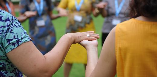 Women from LWF member churches in Asia take part in an exercise, holding hands. Photo: LWF/A. Danielsson