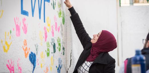Zarqa, Jordan: Incentive-Based Volunteer Esraa from Jordan paints her handmark on the wall of the Lutheran World Federation community centre in Zarqa. Through a variety of activities, the Lutheran World Federation community centre in Zarqa serves to offer psychosocial support and strengthen social cohesion between Syrian, Iraqi and other refugees in Jordan and their host communities. Photo: LWF/Albin Hillert
