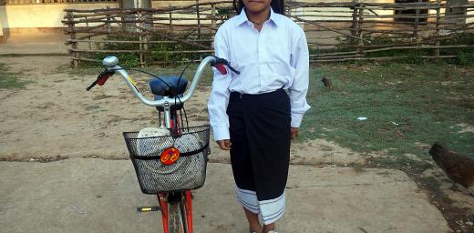 Chanset with her uniform and bicycle in front of her school. Photo: LWF/P. Simayvanh