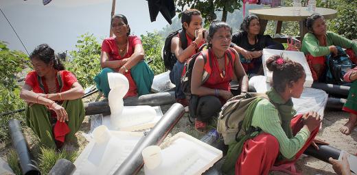 Sita, middle, and neighbours sitting among emergency toilet kits. Photo: Lucia de Vries