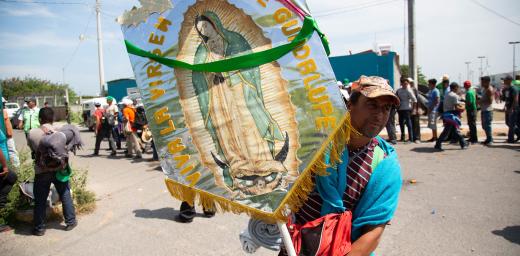 Walking under the protection of the Virgin of Guadalupe, JuchitÂ·n, Oaxaca. This man carried her image, almost as if it were a religious procession, all the way from the border with Guatemala. Photo: LWF/ Sean Hawkey