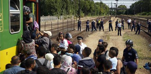 Hungarian police form a cordon as refugees board a train for northern Europe. Photo: MTI