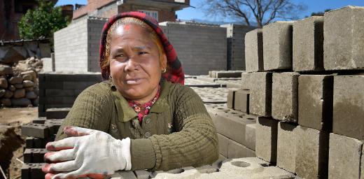 A woman rests from stacking bricks in Sanogoan, Kathmandu valley. Photo: ACT Alliance/Paul Jeffrey