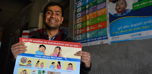 Posters, like the one held by counselor Pradeep Subedi, show the psychological impact of earthquakes on children. Photo: LWF/Lucia de Vries