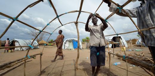 Men in South Sudan reconstruct their house after the village was destroyed in Jonglei. Photo: ACT/ Paul Jeffrey
