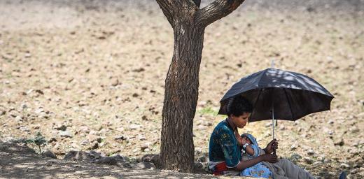 A woman nurses her child in the shade of a tree trunk in Lalibela, Ethiopia. Photo: Magnus Aronsson/ Church of Sweden