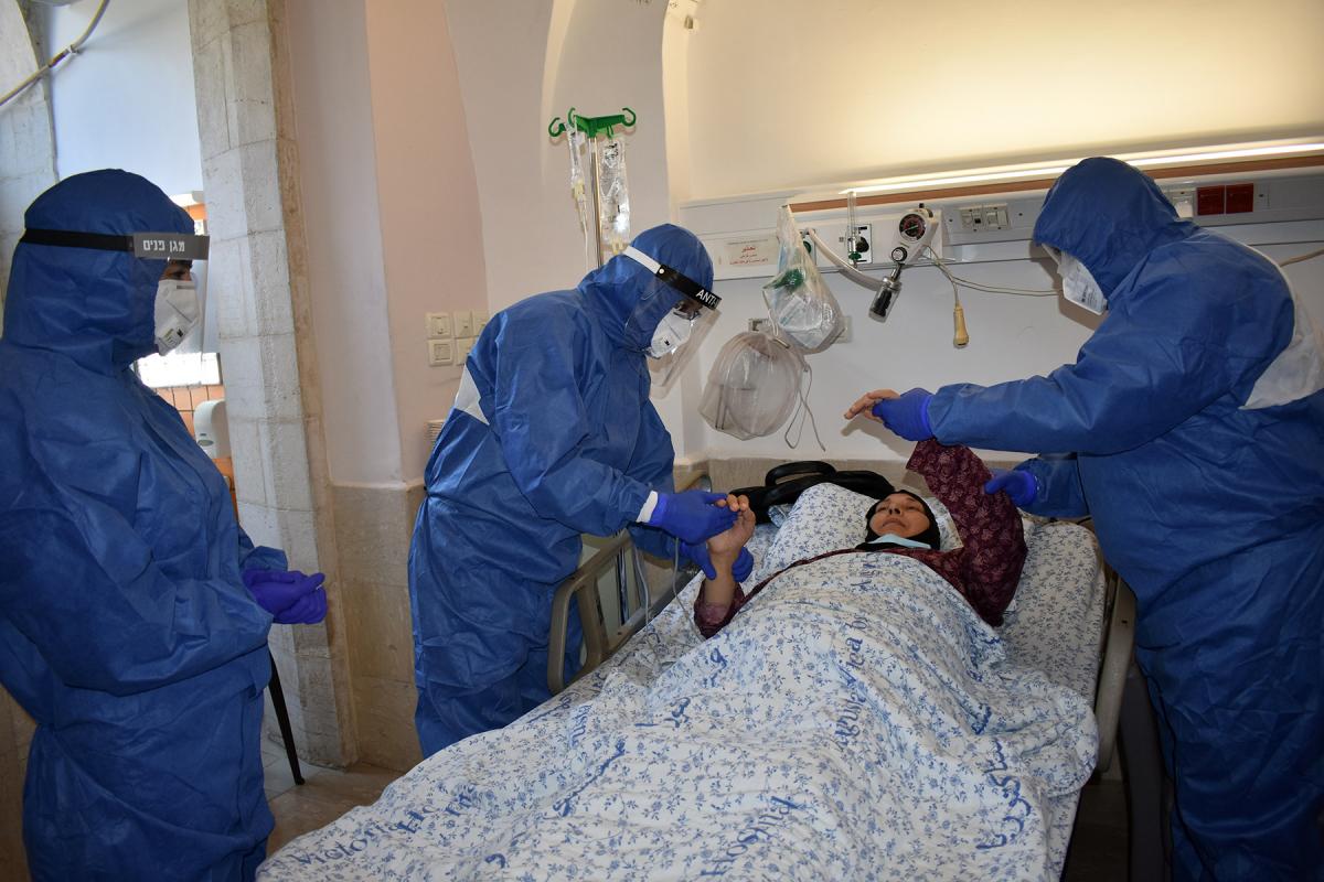 Dr  Ali Sabateen, who is head of infectious diseases unit and of the Coronavirus Center, comforts a patient at Augusta Victoria Hospital, Jerusalem. Photo: LWF/AVH/Ezdihar Shaheen