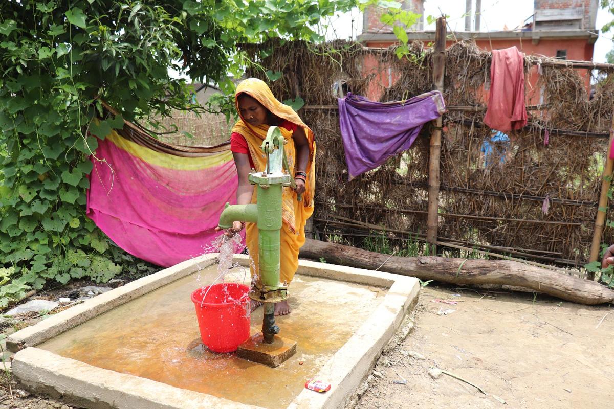 Ms. Rohini Devi Paswan, a resident of Dhanusa, drawing water from a newly constructed hand pump – Photo credit: Suman Rai/LCWS