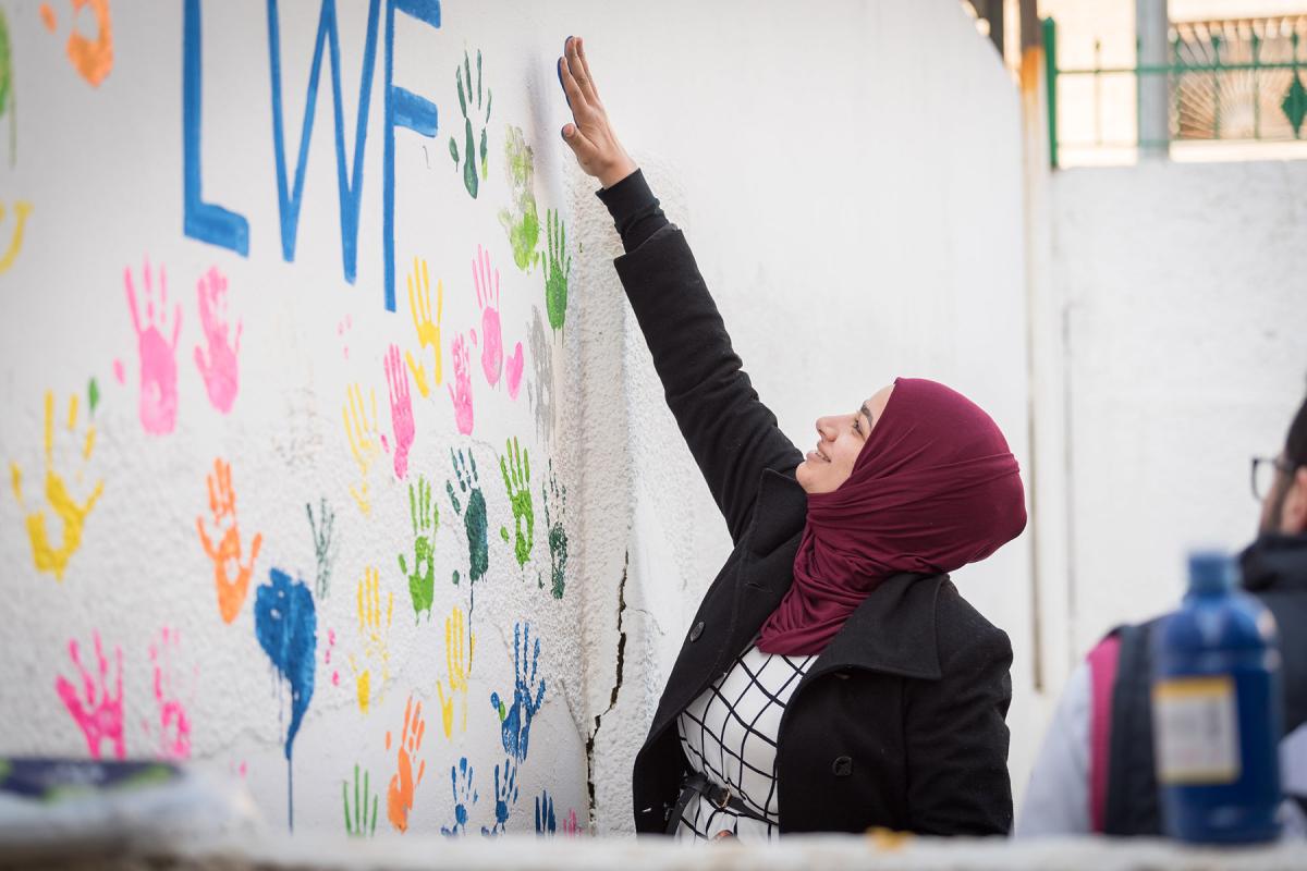 Zarqa, Jordan: Incentive-Based Volunteer Esraa from Jordan paints her handmark on the wall of the Lutheran World Federation community centre in Zarqa. Through a variety of activities, the Lutheran World Federation community centre in Zarqa serves to offer psychosocial support and strengthen social cohesion between Syrian, Iraqi and other refugees in Jordan and their host communities. Photo: LWF/Albin Hillert