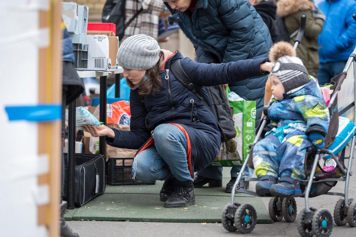 Ukrainian refugee woman Alona looks at supplies at one of the aid workers’ stands at Nyugati train station in Budapest. Alona, her 1.5-year-old son, and her mother arrived from Ukraine on 6 March, following a 26-hour long journey from the capital city Kyiv. All photos: LWF/Albin Hillert