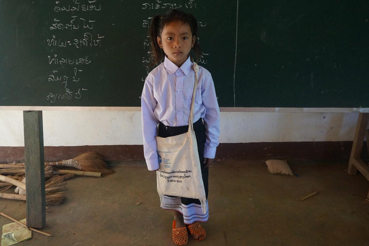 Chanset, an ethnic Khmu girl in northern Laos, with school uniform, books and other items provided by LWF as part of a program to provide access to quality education for girls. Photo: LWF/P. Simayvanh